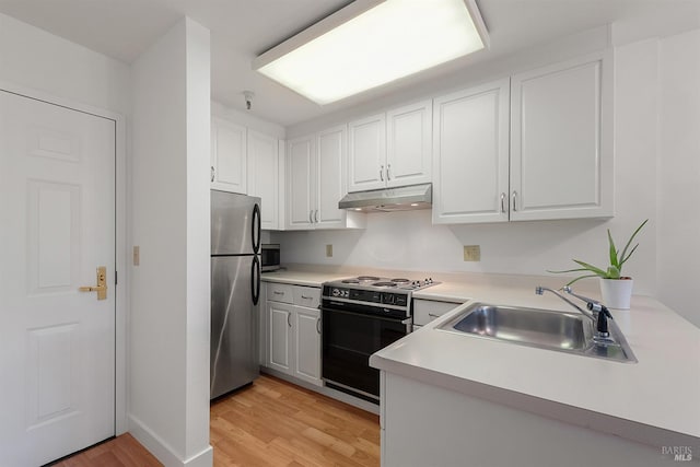 kitchen featuring appliances with stainless steel finishes, sink, white cabinetry, and light hardwood / wood-style floors