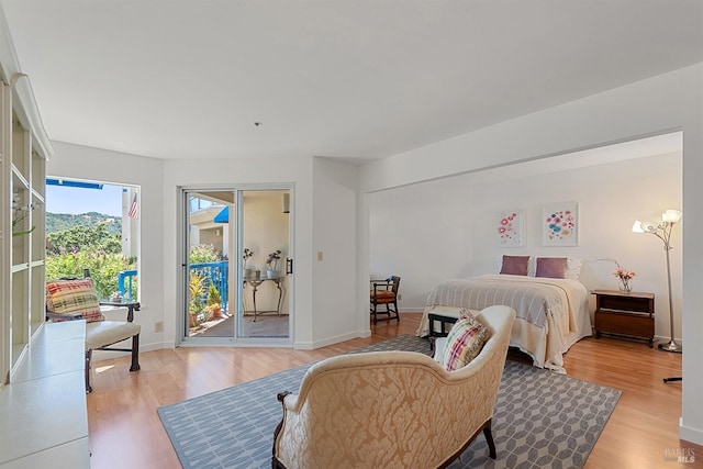 bedroom with access to outside and light hardwood / wood-style floors