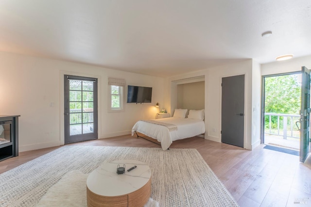 bedroom with access to exterior and light wood-type flooring