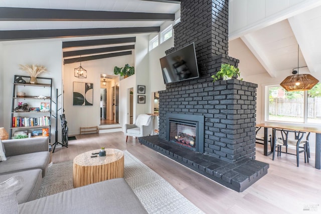 living room featuring beam ceiling, high vaulted ceiling, hardwood / wood-style floors, and a fireplace