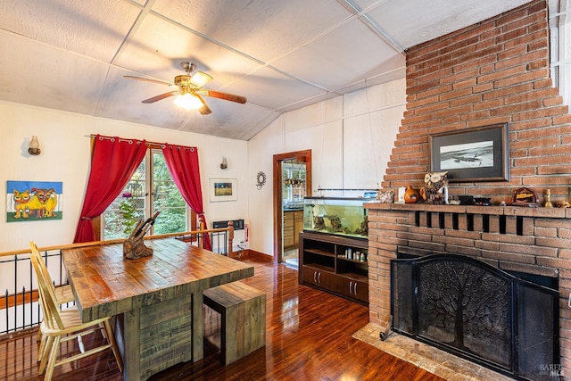 dining room featuring ceiling fan, dark hardwood / wood-style floors, and a fireplace