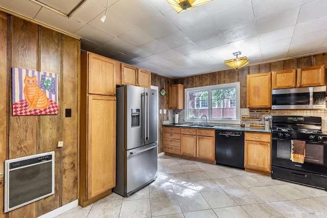 kitchen featuring black appliances, decorative backsplash, heating unit, light tile patterned flooring, and sink