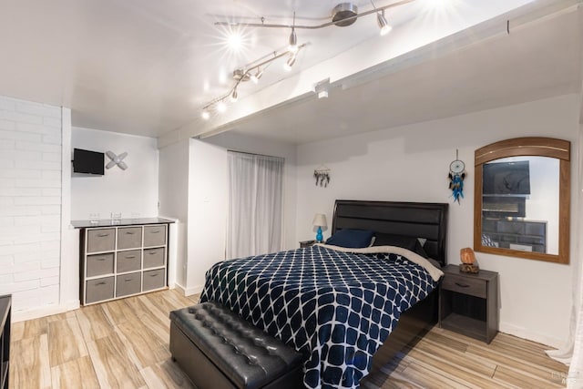 bedroom featuring track lighting and light hardwood / wood-style flooring