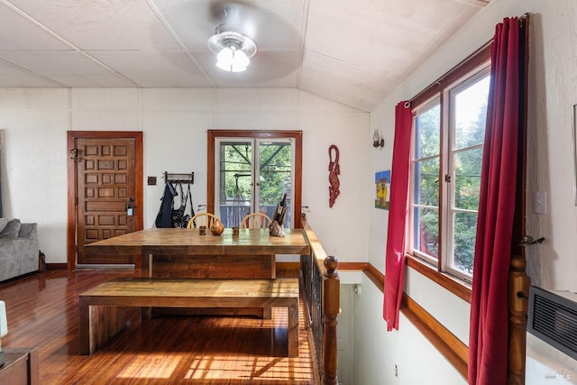 dining room with lofted ceiling, hardwood / wood-style flooring, and a healthy amount of sunlight