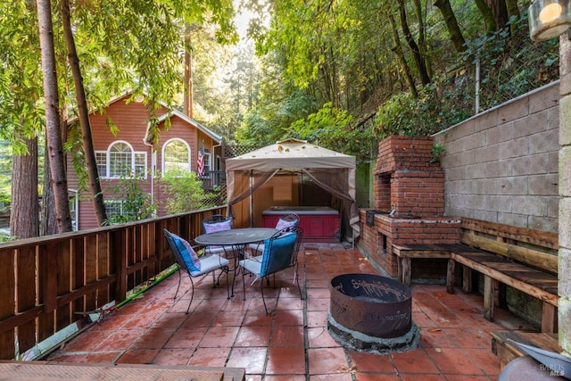 view of patio / terrace featuring a gazebo, a fire pit, and a jacuzzi