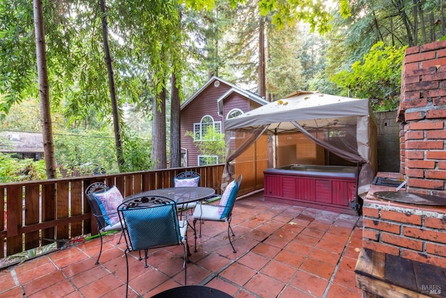 view of patio with a hot tub and a gazebo