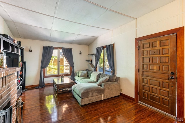 living room with dark hardwood / wood-style floors and a drop ceiling