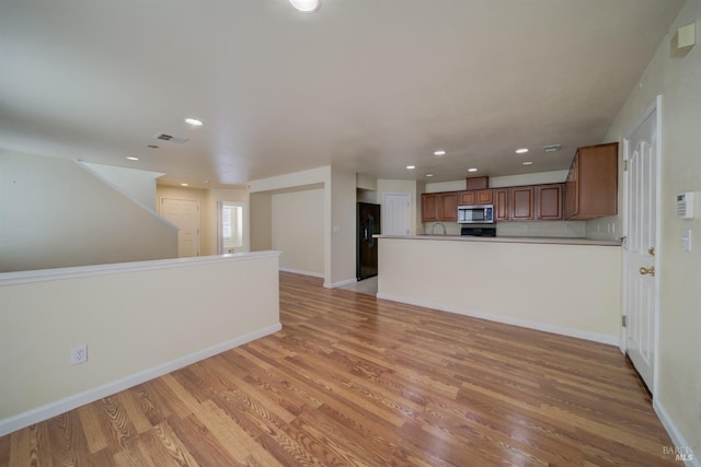 kitchen with black fridge and light hardwood / wood-style flooring