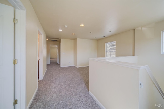 hall with light colored carpet