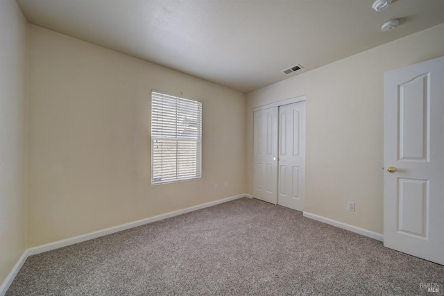 unfurnished bedroom featuring carpet and a closet