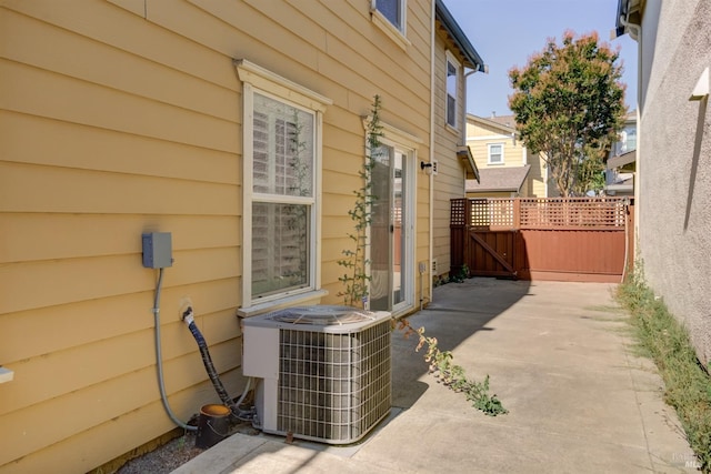 view of side of property with cooling unit and a patio area