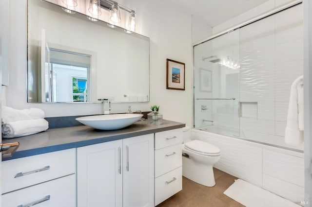 full bathroom with enclosed tub / shower combo, vanity, tile patterned floors, and toilet