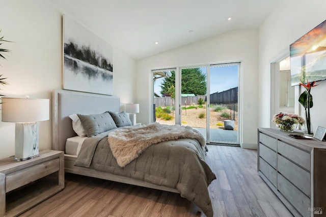 bedroom with vaulted ceiling, access to exterior, and light wood-type flooring