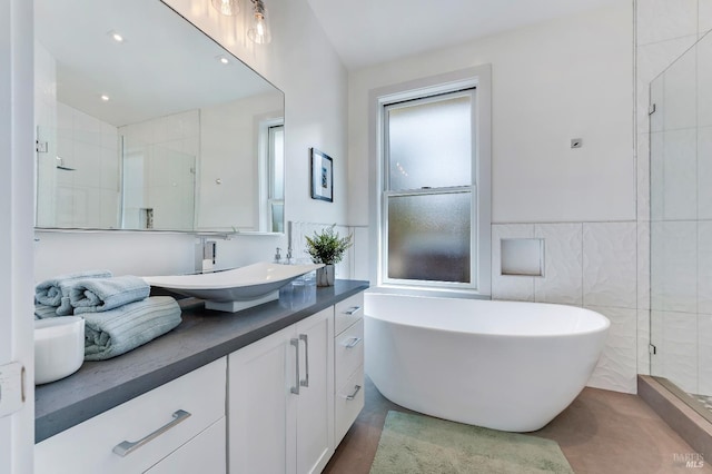 bathroom with vanity, plus walk in shower, and tile walls