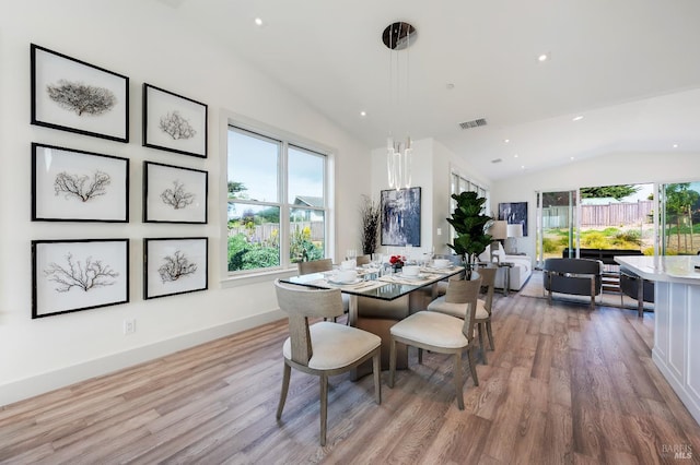 dining area with lofted ceiling, light hardwood / wood-style floors, and a healthy amount of sunlight