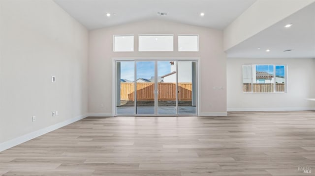 unfurnished living room featuring vaulted ceiling and light hardwood / wood-style floors