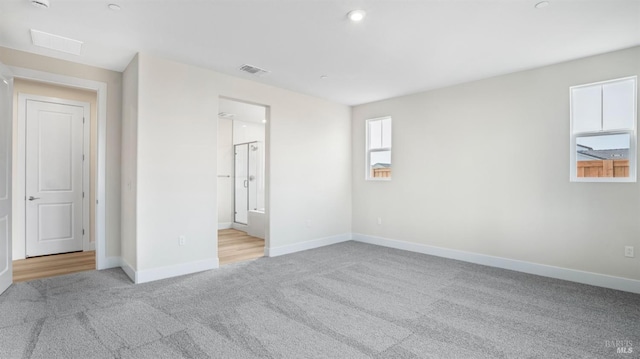 interior space featuring ensuite bath and light carpet