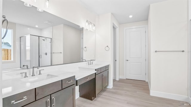 bathroom with vanity, walk in shower, and hardwood / wood-style floors