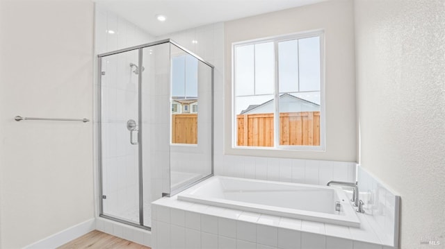 bathroom featuring separate shower and tub and wood-type flooring