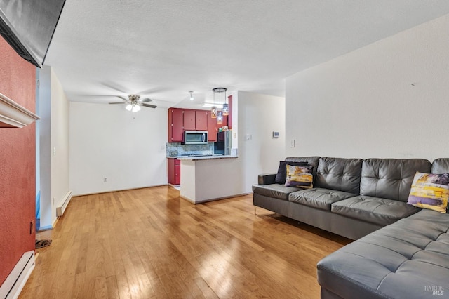 living room with a textured ceiling, light hardwood / wood-style floors, ceiling fan, and a baseboard heating unit