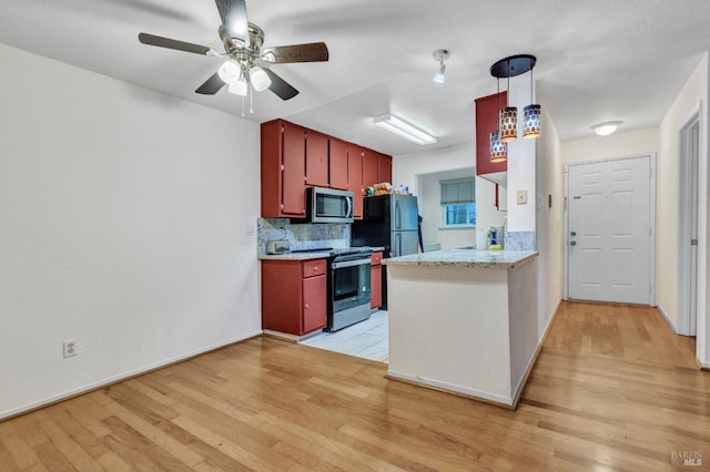 kitchen with kitchen peninsula, appliances with stainless steel finishes, decorative backsplash, ceiling fan, and light hardwood / wood-style floors