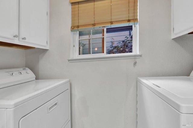 washroom with separate washer and dryer and cabinets