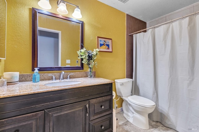 bathroom featuring tile patterned floors, vanity, toilet, and a textured ceiling