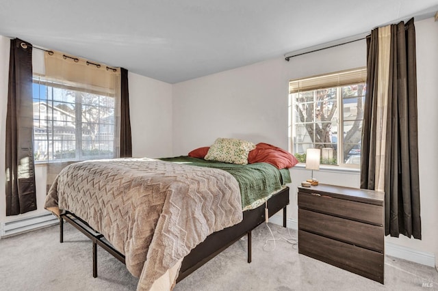 carpeted bedroom with multiple windows and a baseboard heating unit