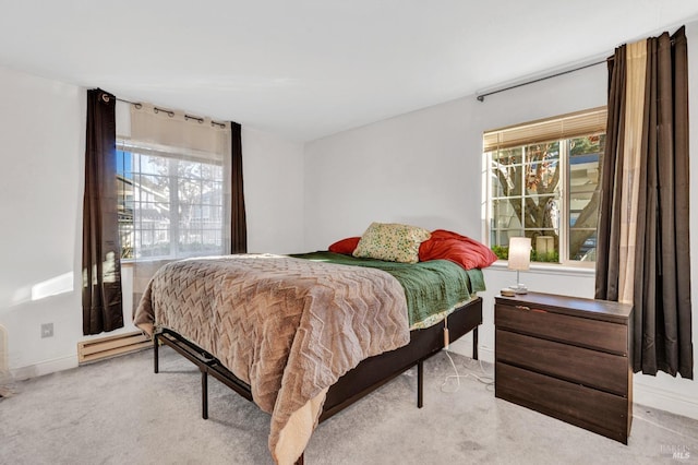 bedroom with light colored carpet and a baseboard radiator