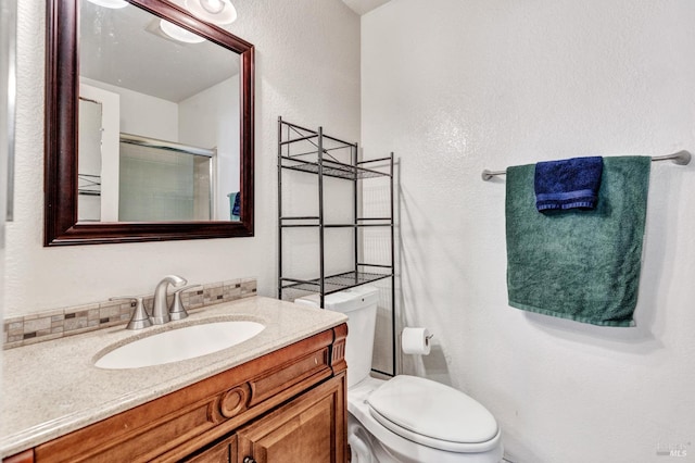 bathroom with vanity, an enclosed shower, and toilet