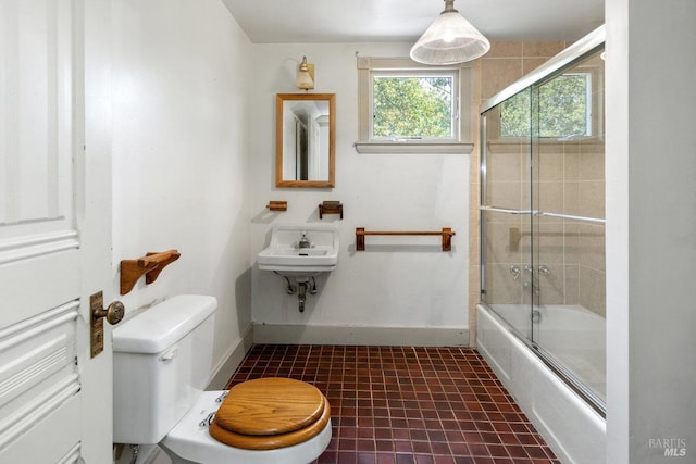 full bathroom featuring tile patterned flooring, enclosed tub / shower combo, sink, and toilet