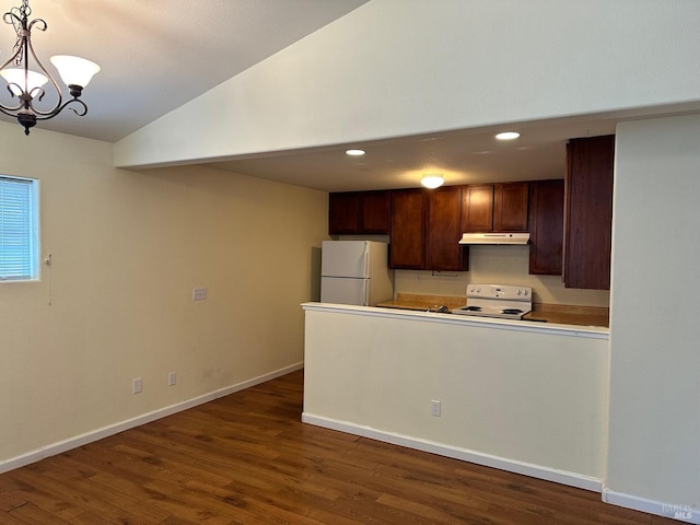 kitchen with lofted ceiling, under cabinet range hood, a peninsula, white appliances, and dark wood-type flooring