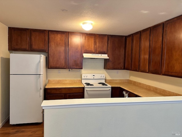 kitchen featuring hardwood / wood-style flooring, a textured ceiling, white appliances, and kitchen peninsula