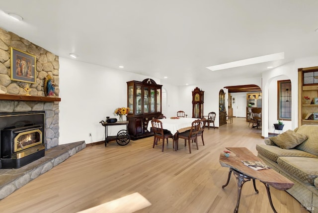 living room featuring a stone fireplace and light hardwood / wood-style floors