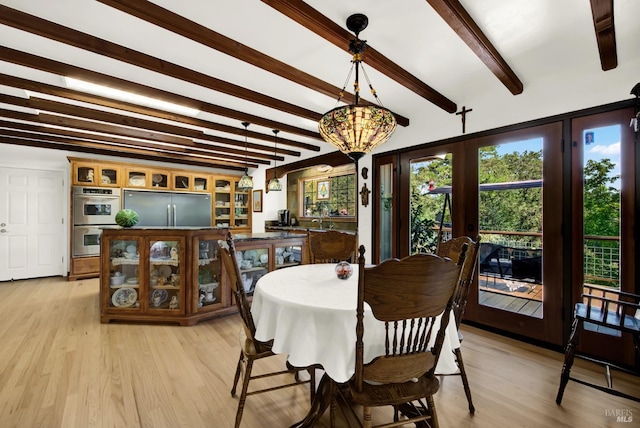 dining room with beamed ceiling, a chandelier, light hardwood / wood-style floors, and french doors