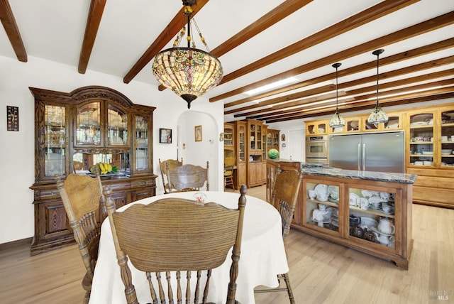 dining area featuring beam ceiling and light wood-type flooring