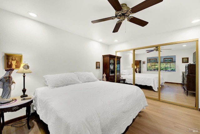 bedroom with hardwood / wood-style flooring, ceiling fan, and a closet