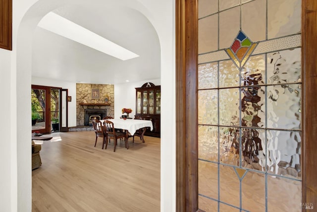 interior space featuring a stone fireplace and light wood-type flooring