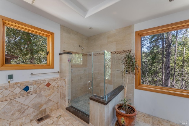 bathroom with a stall shower, visible vents, and tile walls