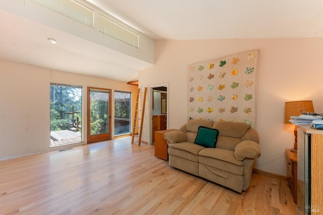 living room with vaulted ceiling, light wood-type flooring, visible vents, and baseboards