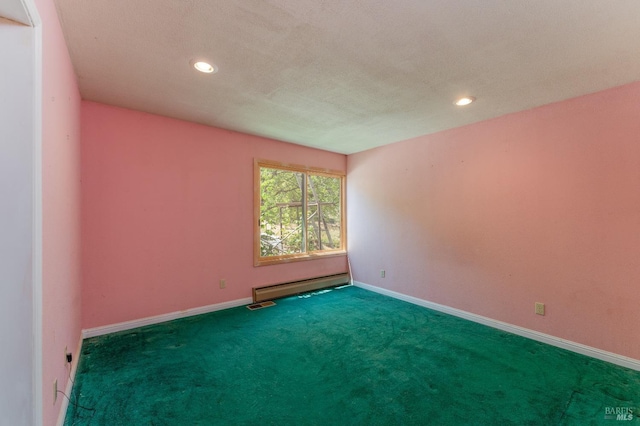 spare room featuring recessed lighting, dark carpet, baseboard heating, a textured ceiling, and baseboards