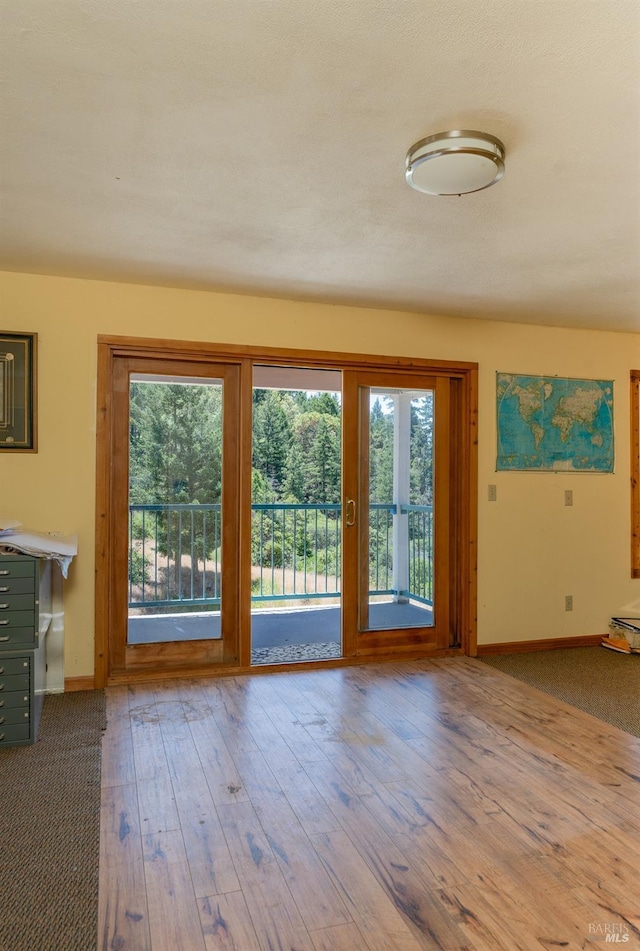 entryway featuring wood-type flooring and baseboards