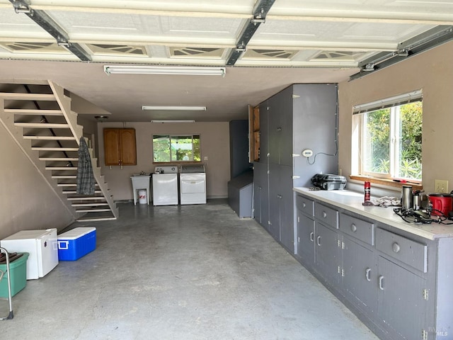 garage featuring sink and washing machine and clothes dryer