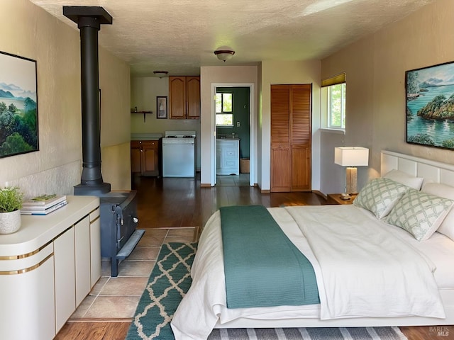 bedroom featuring light hardwood / wood-style flooring, a textured ceiling, and a closet