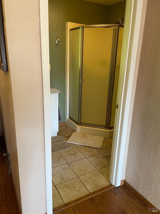 bathroom featuring walk in shower and wood-type flooring