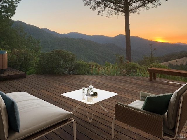 deck at dusk featuring a mountain view