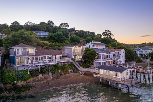 aerial view at dusk featuring a water view