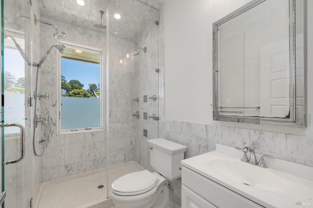 bathroom with tile walls, vanity, an enclosed shower, and toilet