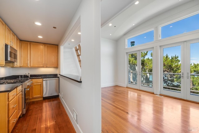 kitchen with light hardwood / wood-style floors, stainless steel appliances, light brown cabinetry, and french doors