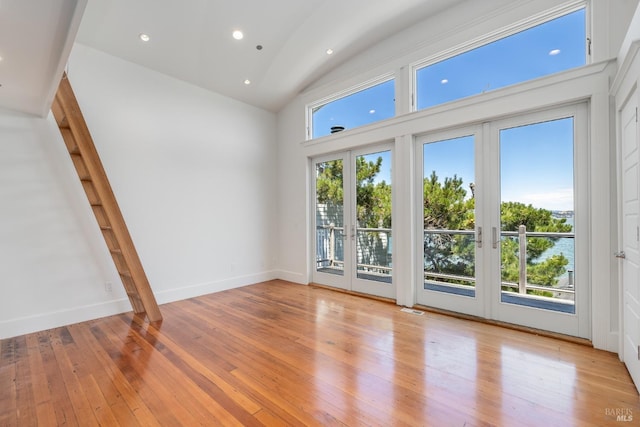 interior space with french doors, high vaulted ceiling, and light hardwood / wood-style floors